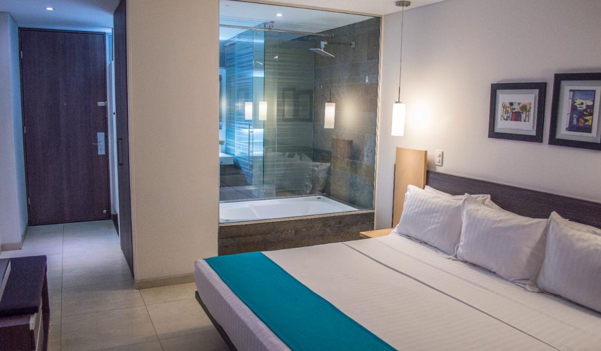 Habitación elegante con cama king y bañera moderna en Hotel Casablanca Cúcuta. Habitación elegante con cama king y bañera con vidrio en Hotel Casablanca Cúcuta.
