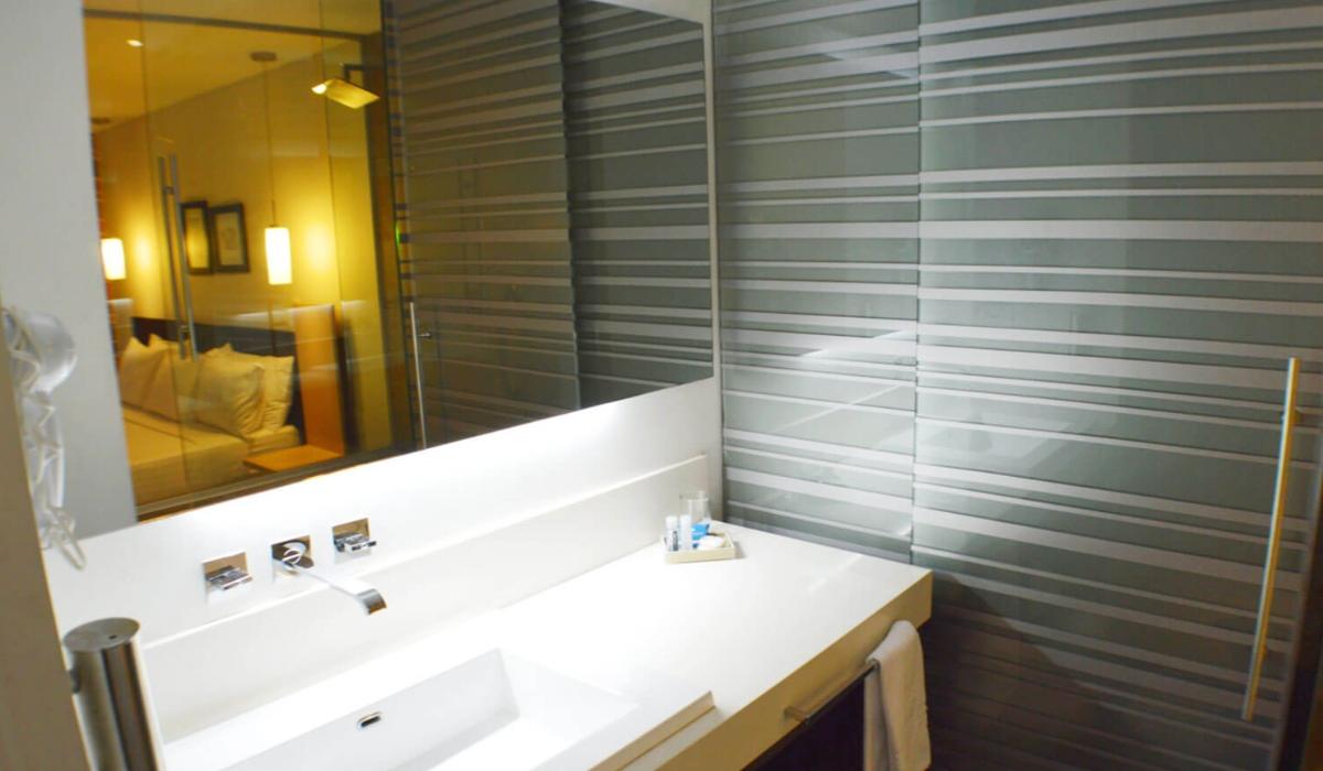 Baño contemporáneo con espejo amplio en Hotel Casablanca Cúcuta. Baño moderno de hotel con espejo grande y diseño elegante en Hotel Casablanca Cúcuta.