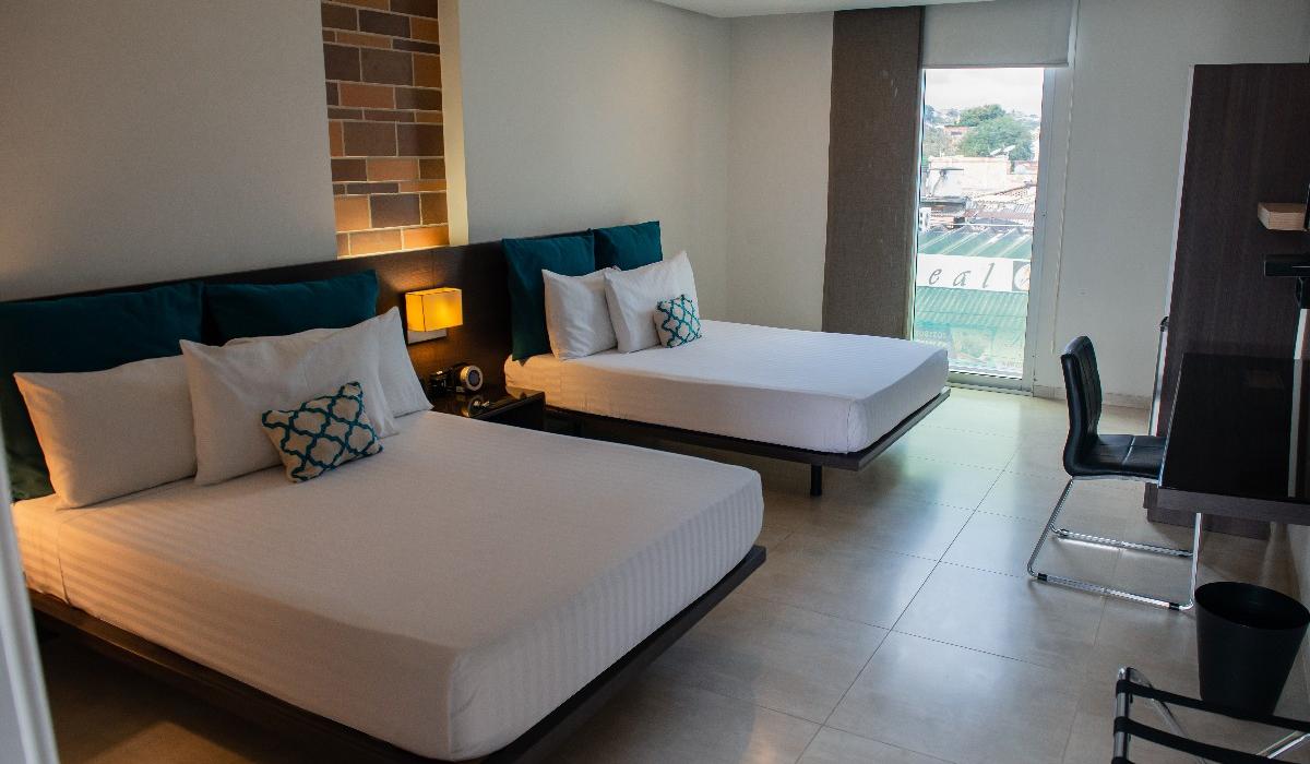 Habitación doble con vista exterior y decoración moderna en Hotel Casablanca Cúcuta. Habitación con dos camas dobles, decoración moderna y vista exterior en Hotel Casablanca Cúcuta.